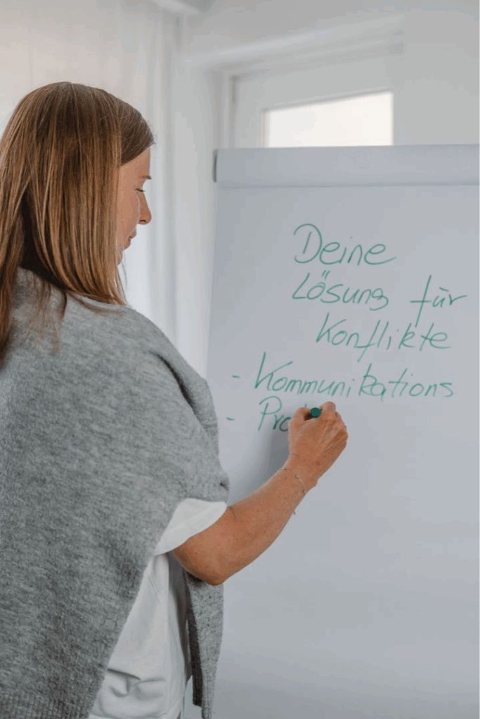 Susanne Niemetz schreibt auf dem Flipchart. Sie schreibt was über Konfliktlösung